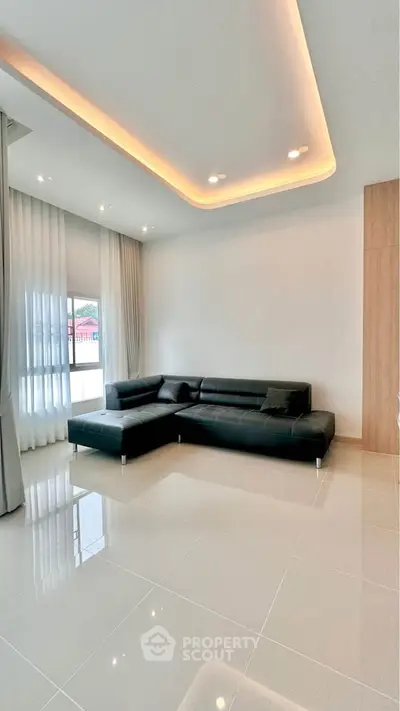 Modern living room with sleek black leather sofa and elegant lighting