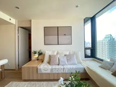 Modern living room with large windows and city view, featuring cozy seating and elegant decor.