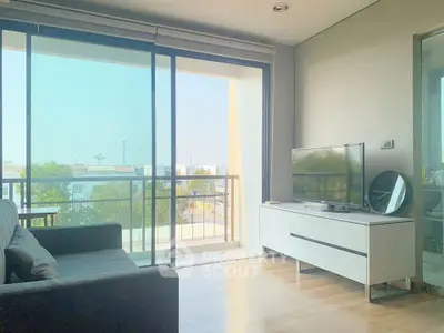 Bright living room with balcony view, modern furniture, and natural light.