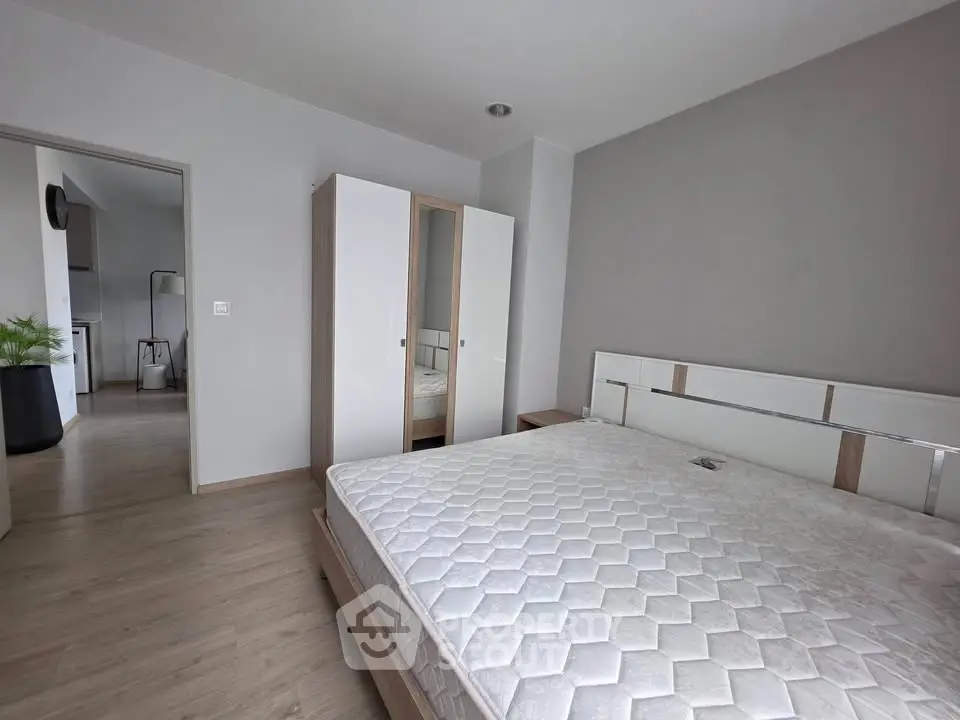 Spacious bedroom with modern design and ample natural light, featuring a comfortable bed and sleek wardrobe.