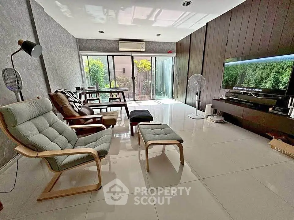 Spacious modern living room with sleek furniture and large windows offering natural light.