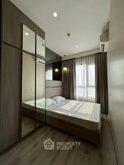 Modern bedroom with large mirrored wardrobe and natural light