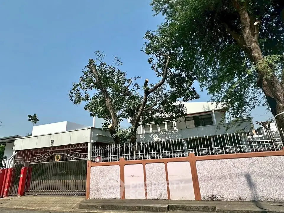 Charming residential property with lush trees and secure fencing, perfect for family living.