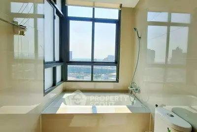 Luxurious bathroom with large window offering stunning city views and modern bathtub.