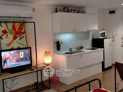 Cozy studio apartment with modern kitchenette and stylish decor, perfect for urban living.