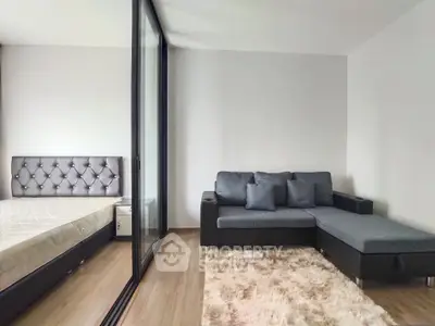 Modern apartment with cozy living room and adjacent bedroom, featuring sleek design and comfortable furnishings.