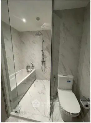 Modern bathroom with sleek marble tiles and glass shower enclosure