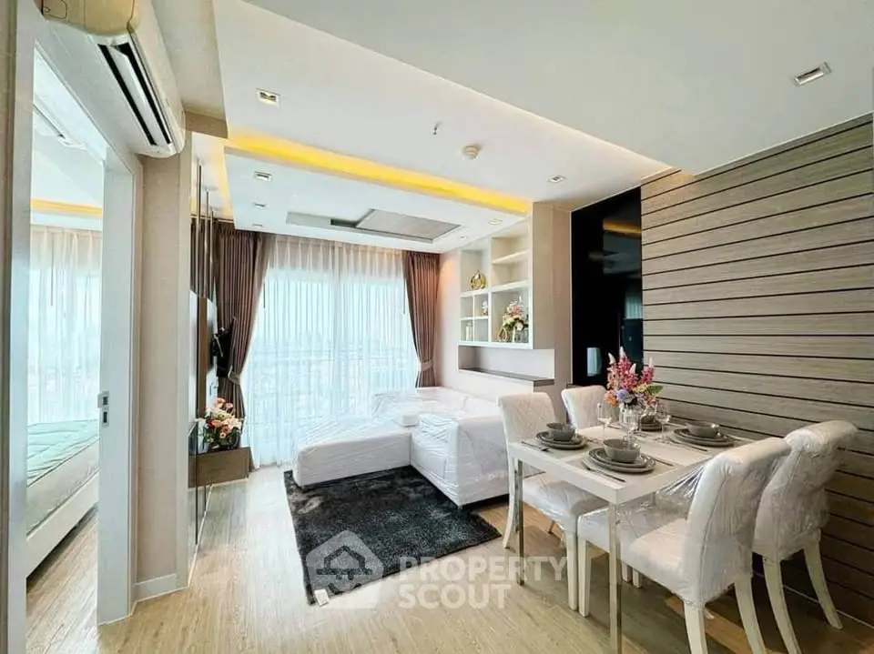 Modern living room with dining area, featuring elegant decor and large windows for natural light.