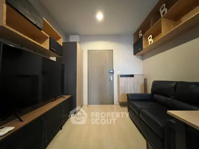 Modern living room with sleek black furniture and wooden accents, featuring a large TV and stylish shelving.