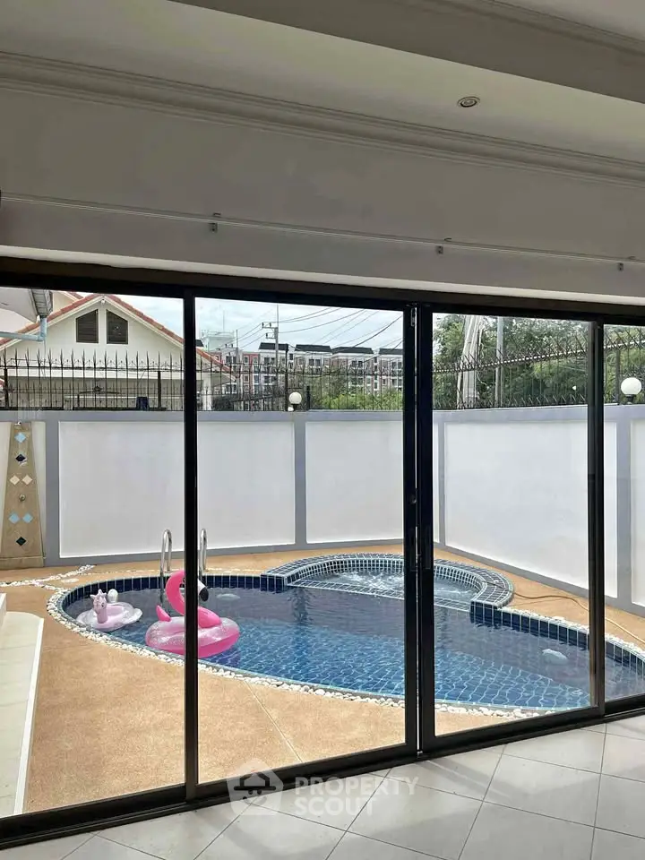 Luxurious private pool view from modern home with sliding glass doors
