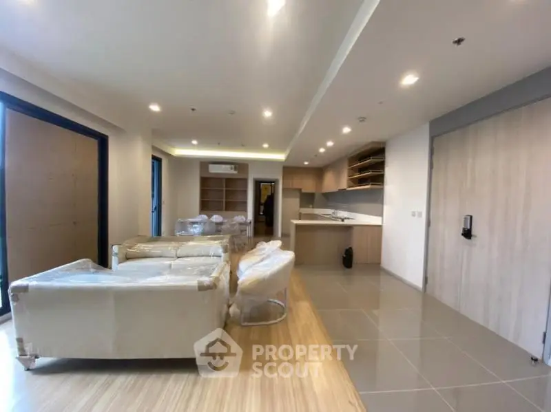 Spacious modern living room with open kitchen layout and stylish furniture in a contemporary apartment.