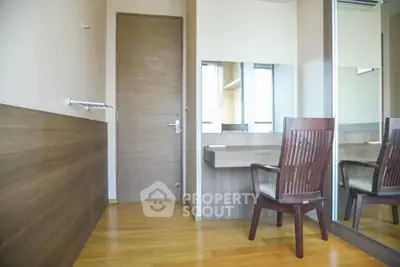 Modern study room with wooden desk and chair, featuring large mirror and natural light.