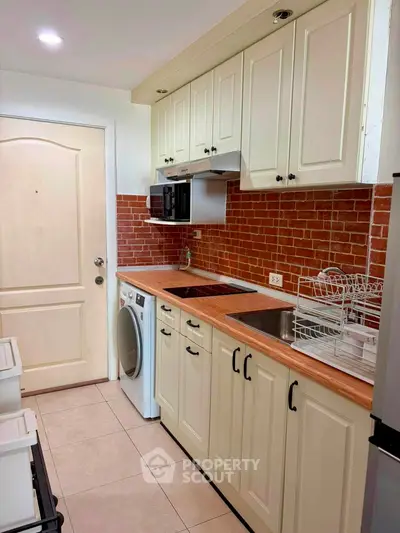 Charming kitchen with brick backsplash and modern appliances in cozy apartment.