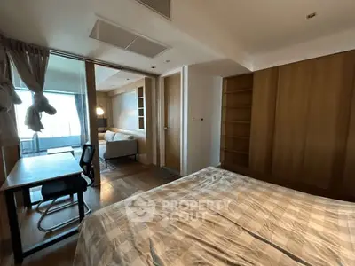 Spacious bedroom with study area and balcony view in modern apartment.