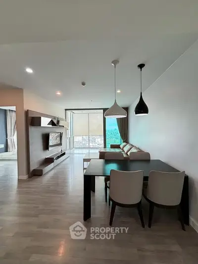 Spacious modern living room with elegant dining area and large windows offering natural light.