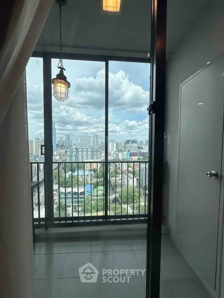 Stunning city view from high-rise balcony with glass doors and modern lighting.