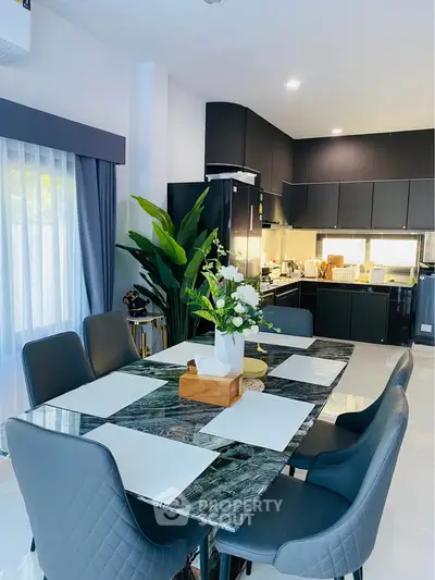 Modern kitchen with sleek black cabinets and elegant dining area