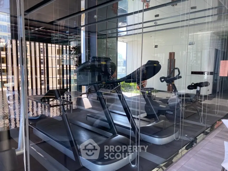 Modern gym with state-of-the-art equipment and city view, perfect for fitness enthusiasts.