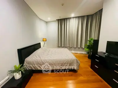 Spacious bedroom with modern decor and wooden flooring