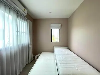 Cozy bedroom with natural light and minimalist design, featuring a single bed and air conditioning.