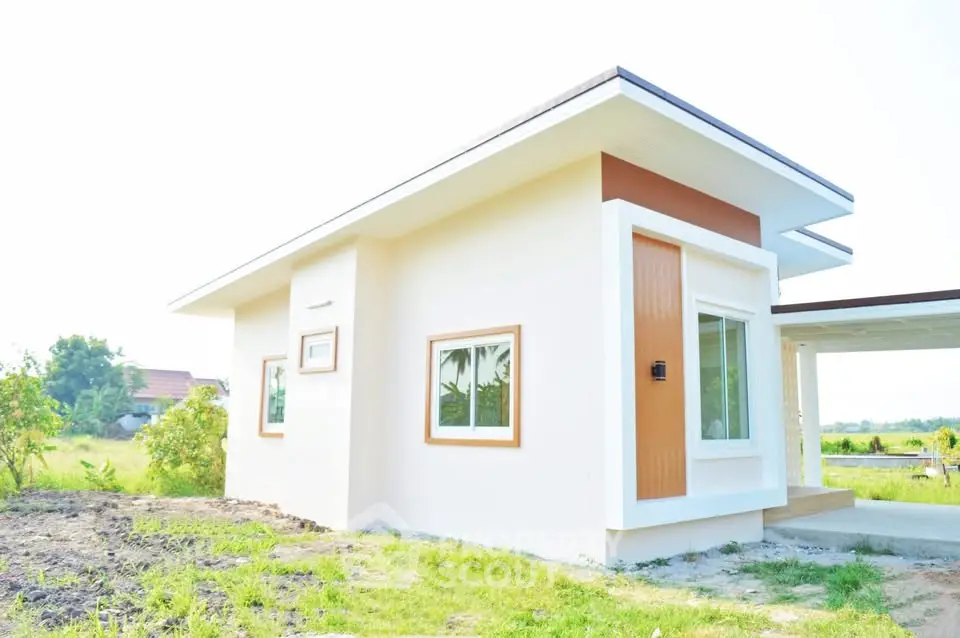 Modern single-story house with minimalist design and large windows in a serene countryside setting.