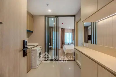 Modern apartment entryway with washing machine and view into bedroom