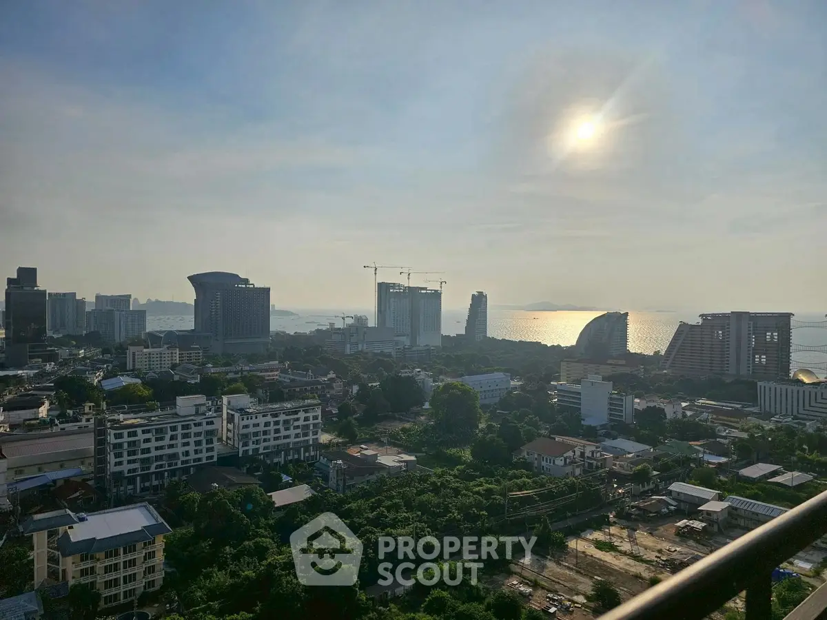 Stunning cityscape view with ocean backdrop and modern architecture at sunset.