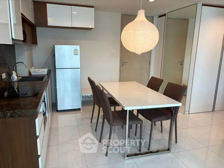 Modern kitchen with sleek dining area and stylish lighting