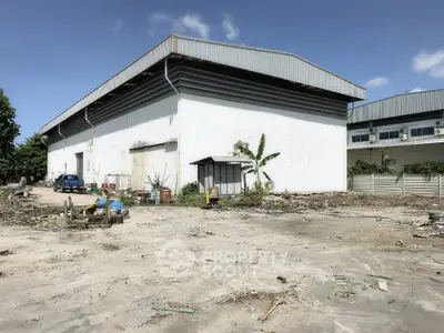 Spacious industrial warehouse with ample outdoor space and clear blue sky.