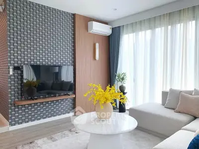 Modern living room with stylish decor, large windows, and cozy seating area.
