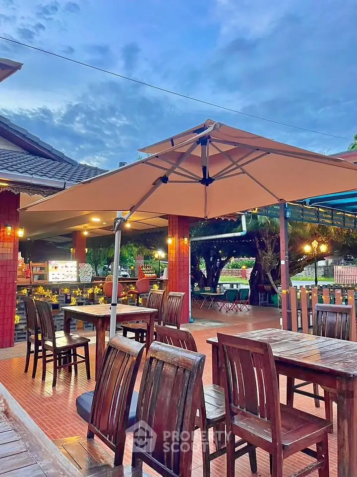Charming outdoor dining area with wooden furniture and large umbrellas, perfect for al fresco meals.