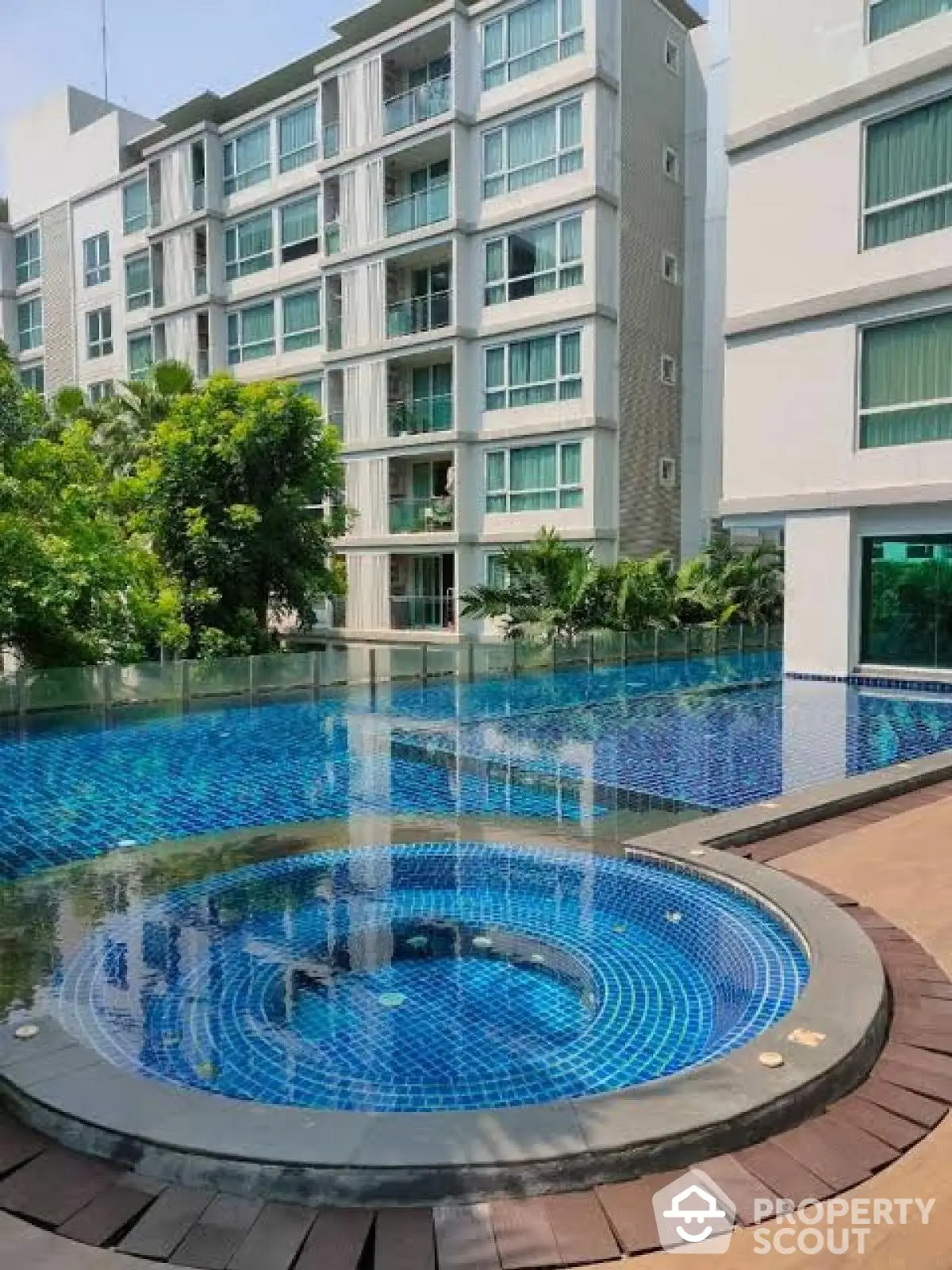 Luxurious apartment complex with stunning pool and modern architecture.