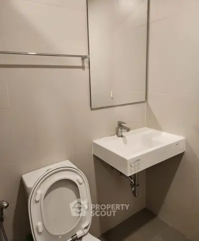 Modern bathroom with sleek sink and toilet in minimalist design.
