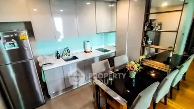 Modern kitchen with sleek cabinets and dining area in stylish apartment