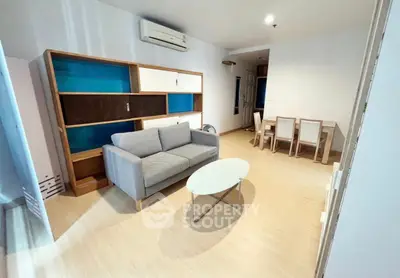 Spacious living room with modern furniture and dining area, perfect for comfortable living.