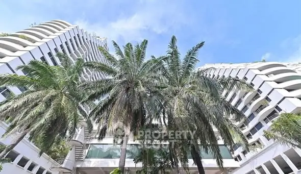 Stunning modern building exterior with unique architecture and lush palm trees.