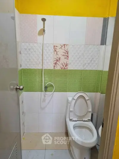 Compact bathroom with colorful tile design and modern fixtures.