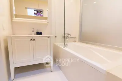 Elegant bathroom with modern bathtub and stylish vanity in a bright, minimalist design.