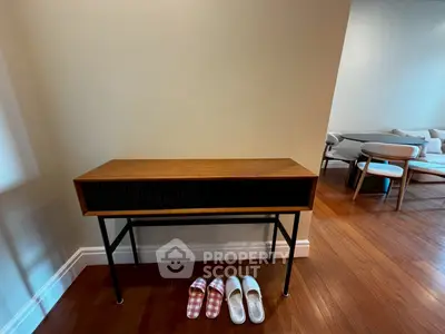 Stylish console table in modern living room with wooden flooring and cozy seating area.