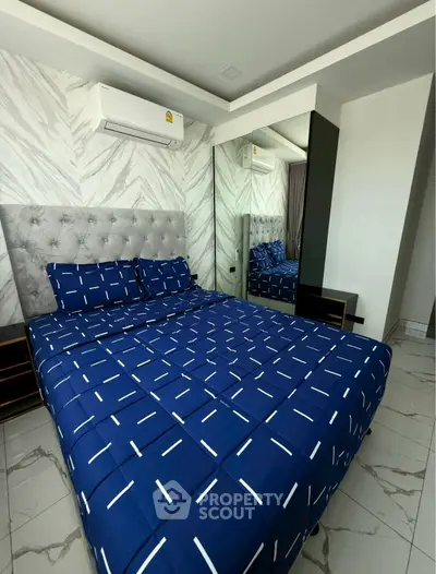 Modern bedroom with stylish decor and air conditioning, featuring a comfortable bed and mirrored wardrobe.