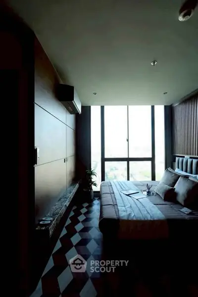 Modern bedroom with large windows and geometric flooring, offering a stylish urban view.