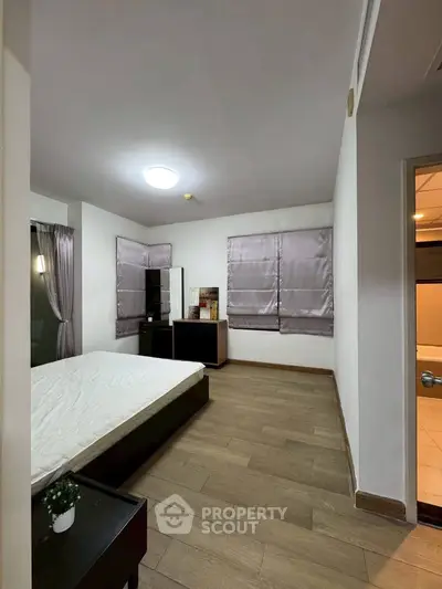 Spacious bedroom with modern decor and wooden flooring