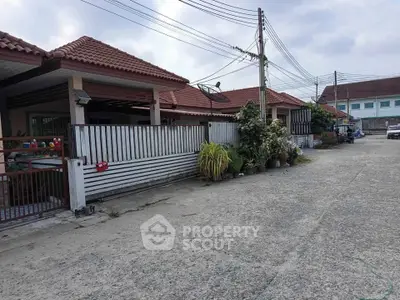 Charming suburban homes with red-tiled roofs and lush greenery in a peaceful neighborhood.