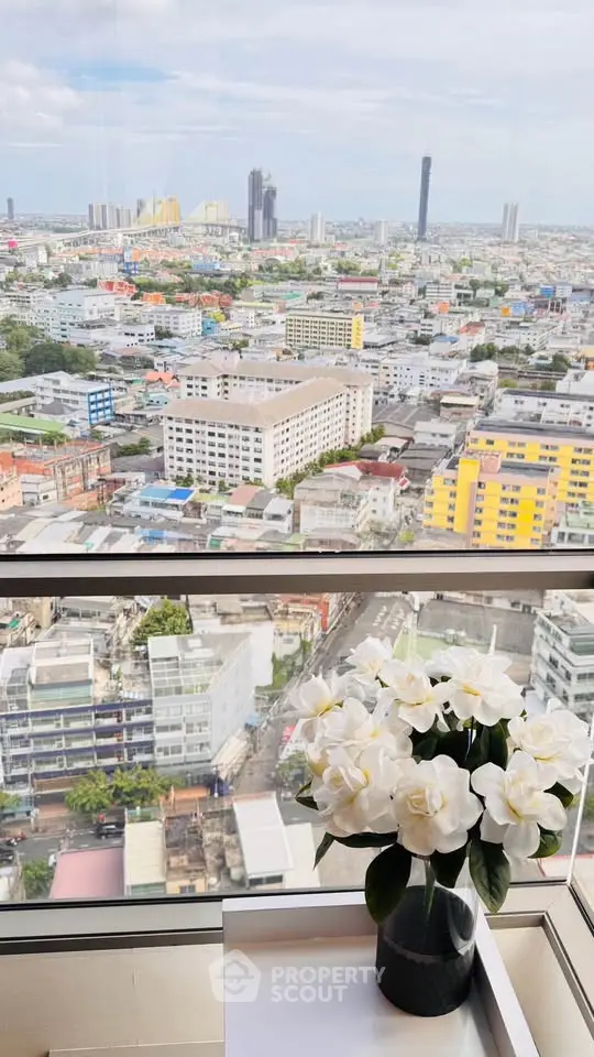 Stunning cityscape view from high-rise apartment with elegant floral decor.