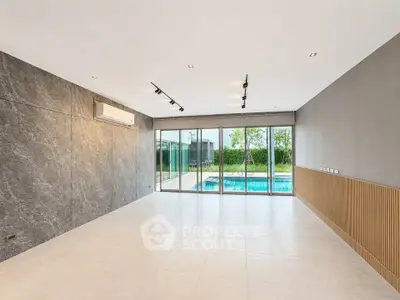 Spacious modern living room with pool view and large windows