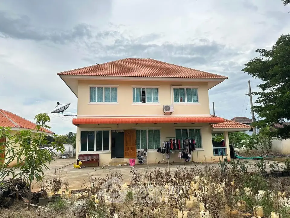 Charming two-story house with red-tiled roof and spacious front yard, perfect for family living.