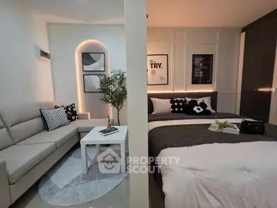 Modern studio apartment with stylish decor, featuring a cozy living area and a comfortable bed.