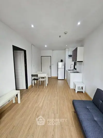 Modern minimalist living room with open kitchen and wooden flooring