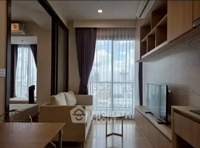 Modern living room with natural light and city view, featuring sleek furniture and open layout.