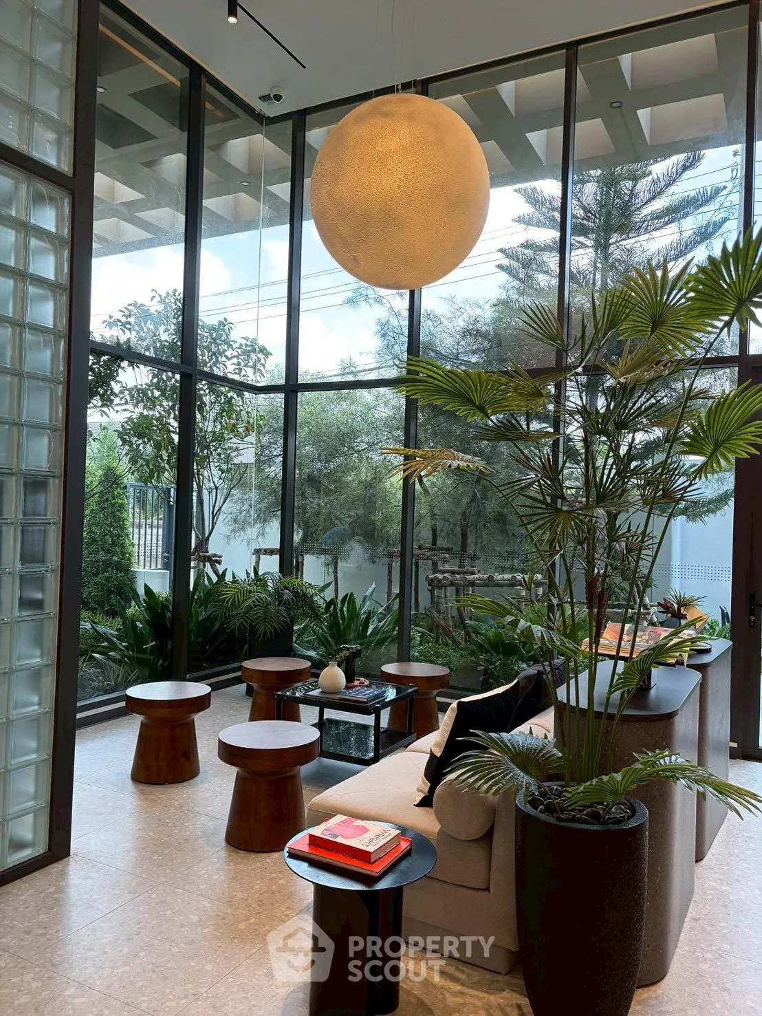 Luxurious living room with floor-to-ceiling windows and lush greenery